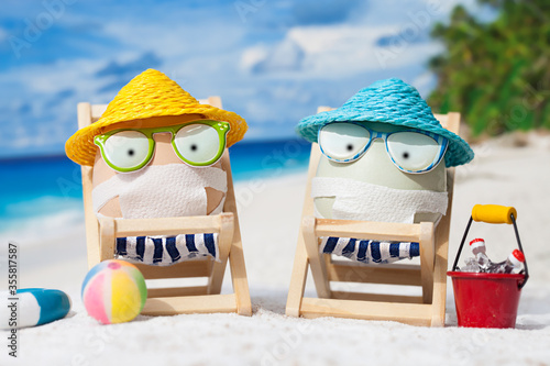 Easter eggs with faces mask at beach. Travel concept. Protection from corona virus