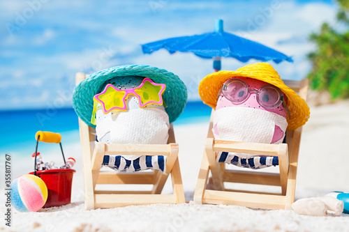Easter eggs with faces mask at beach. Travel concept. Protection from corona virus