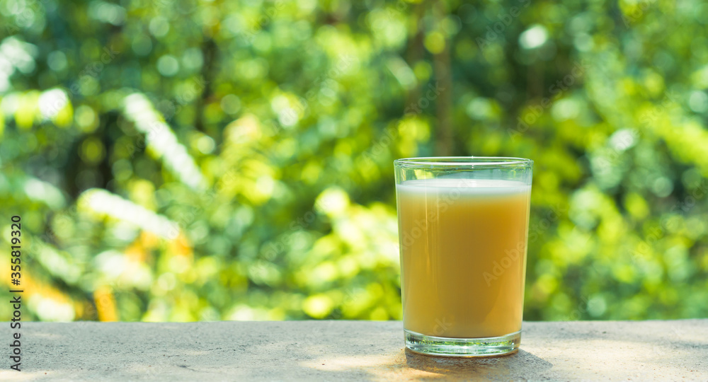 fresh orange juice in clear grass with fresh green nature blurry background. fresh orange juice in clear grass with fresh green nature blurry background.