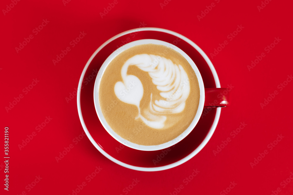 Hot cappuccino on red table with selective focus on the latte art