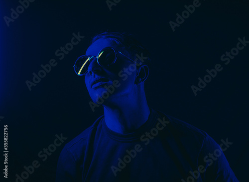 portrait of a man. Male. Neon. Dark background. Sunglasses. 