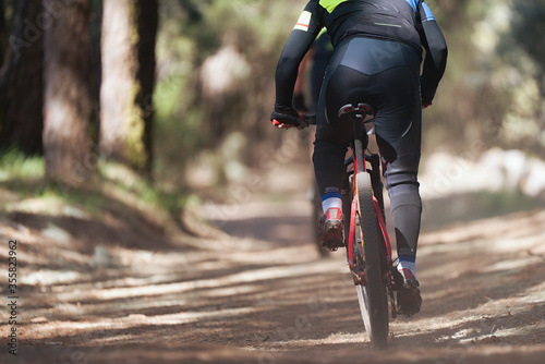 Athletes mountain biking on forest trail, mountain bike race 