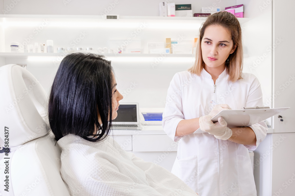 Young intern female student undergoes medical practice in a private clinic. Prescription. Beautiful girl receives social health insurance examination. Virus population screening