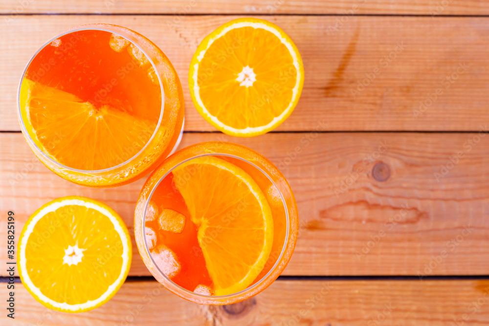 Aperol spritz cocktail on a wooden boards. Two glasses of aperol spritz with orange slised. Summer cocktail in glass. Top view. Copy space Aperol spritz cocktail on a wooden boards. Two glasses of aperol spritz with orange slised. Summer cocktail in glass. Top view. Copy space