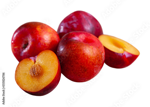 Whole and halves red appetizing plums