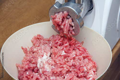 Cooking minced pork meat with a meat grinder. Home-made meat semi-finished products. Minced pork. Semi-finished products for storage in the refrigerator. Meat grinder close up