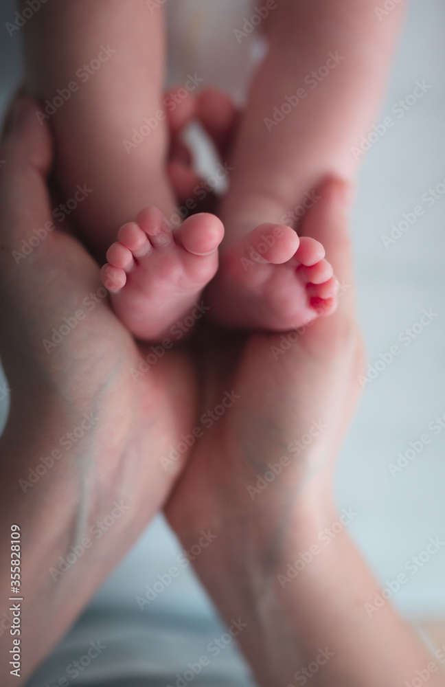 Woman hands holding baby feet closeup Woman hands holding baby feet closeup