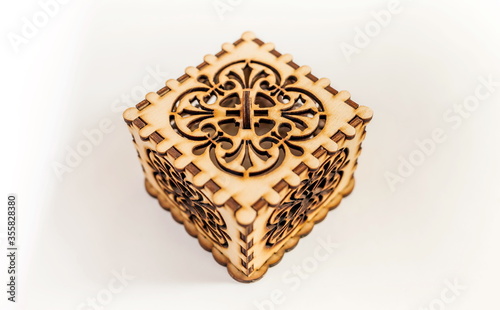The box is made of plywood with a pattern cut by laser cutting on a white background