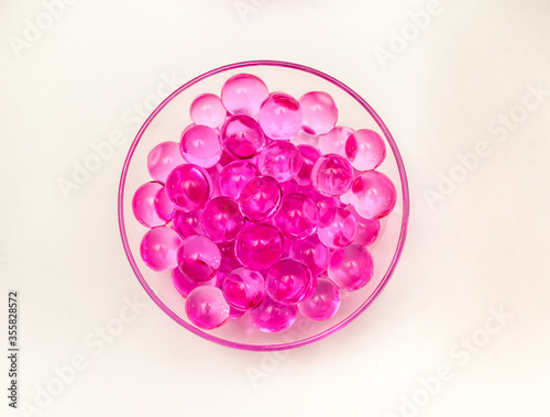 Pink helium balloons in a glass glass on a white background