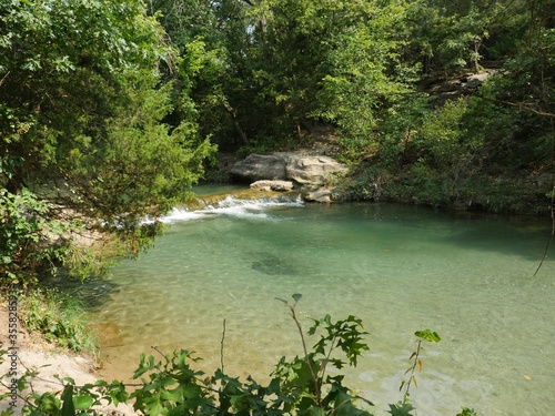 Scenic view of clear waters flowing in a small waterfalls and stream in the forest