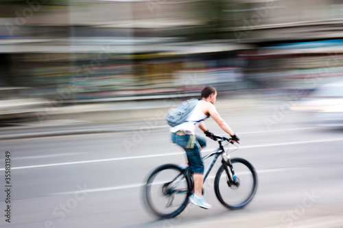 Blurry panning shot of young man speeding on a bike