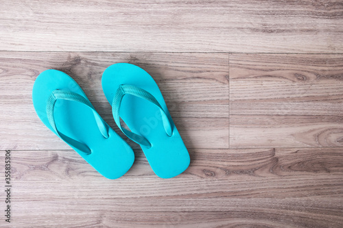 Blue flip flops or .slippers on wooden background.Top view or flat lay background with copy space for text.