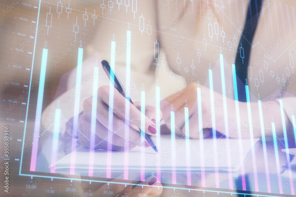 Double exposure of hands making notes with forex chart huds. Stock market concept. Double exposure of hands making notes with forex chart huds. Stock market concept.