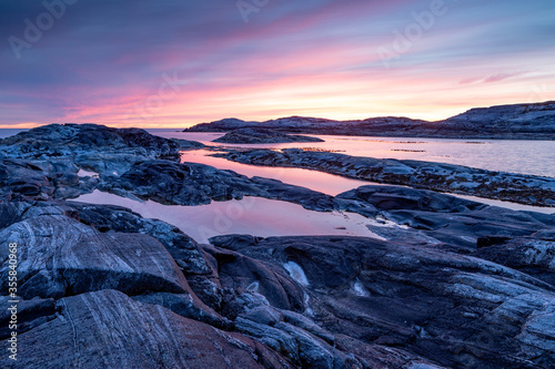 Purple light on smoth rocs by the sea in Norway