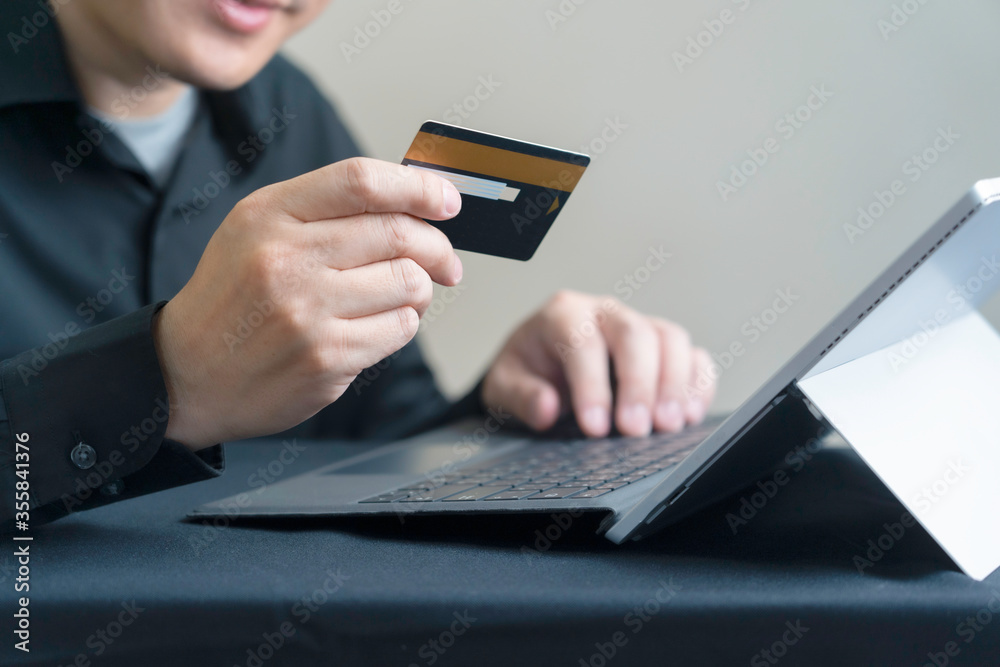 Man paying online by credit card with digital tablet or computer laptop, Internet banking or ecommerce concept Man paying online by credit card with digital tablet or computer laptop, Internet banking or ecommerce concept