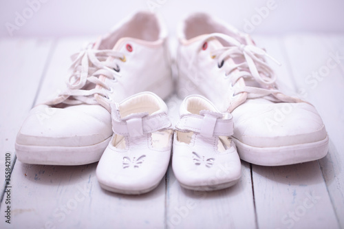 Daddy's baby's sneakers, on white wooden background, fathers day concept.