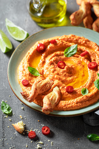 Fresh tomato hummus with breadsticks and basil