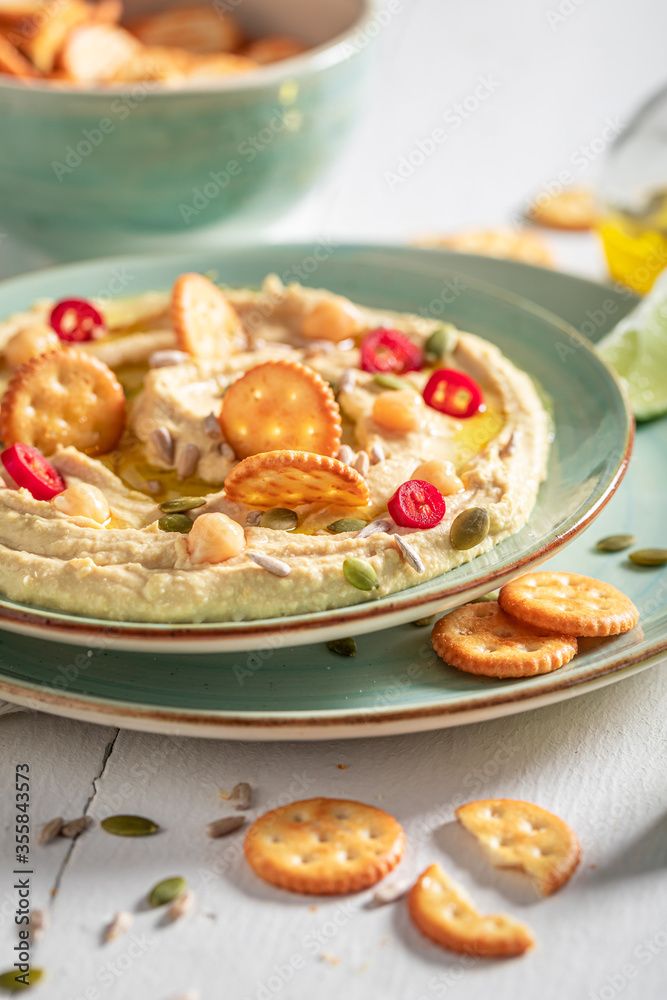 Homemade hummus with crackers and pumpkin seeds