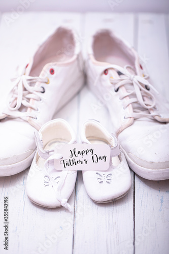 Man's and kid's shoes on white wooden background. Happy father's day concept.