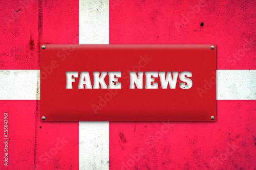 Fake news. The inscription on a red plate on the background of the flag of Denmark. Information