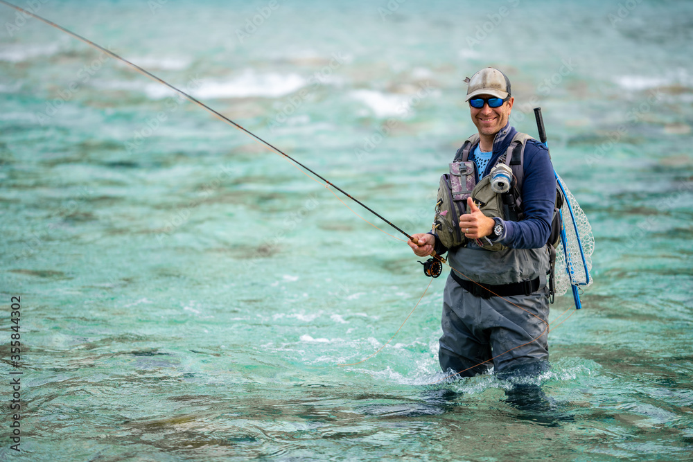 Close up of a smiled fly fisherman posing with thumb up Close up of a smiled fly fisherman posing with thumb up