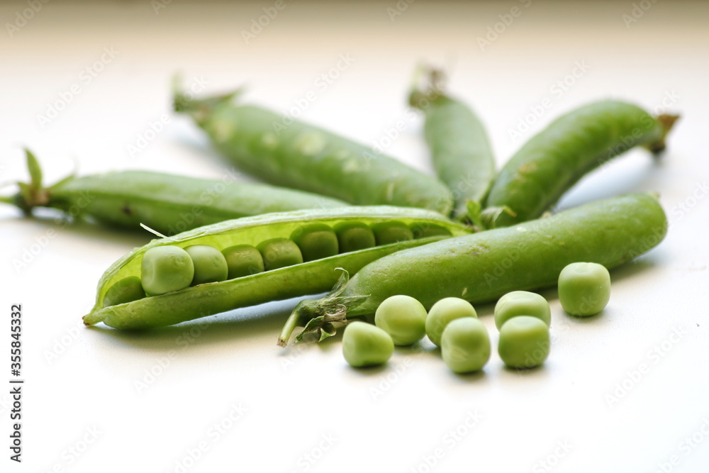 Green peas, fresh in the tricks, on a white background, close-up Green peas, fresh in the tricks, on a white background, close-up