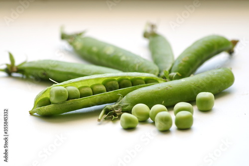 Green peas, fresh in the tricks, on a white background, close-up