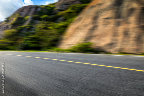 Motion blurred asphalt road and mountain natural landscape on a sunny day.