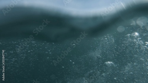 Wave on moving water surface close up in the middle of the screen. Under Water Surface in the middle of the sea