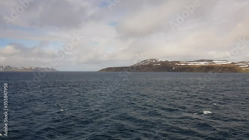 mighty sea and snowy mountain view sailing a ship in Finnmark, northern Norway photo