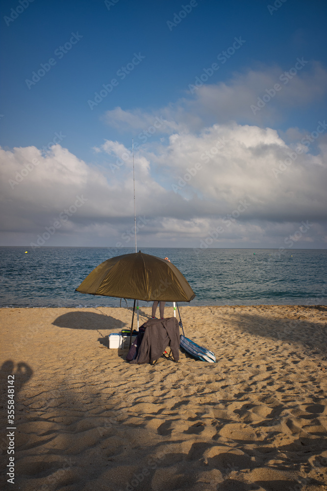 Paraguas de pescador frente al mar con nubes. 
