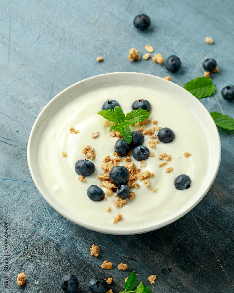 Greek yogurt with granola and blueberries in white bowl. Healthy breakfast food or snack Greek yogurt with granola and blueberries in white bowl. Healthy breakfast food or snack