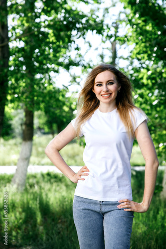 Attractive girl in a white T-shirt on the street. Mock-up.