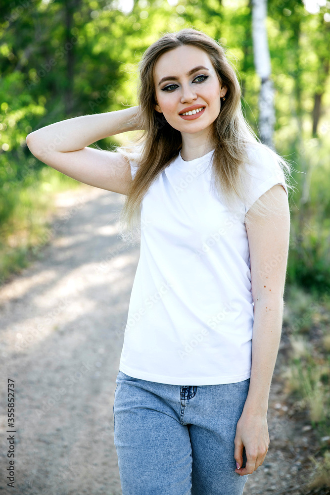 Attractive girl in a white T-shirt on the street. Mock-up. Attractive girl in a white T-shirt on the street. Mock-up.