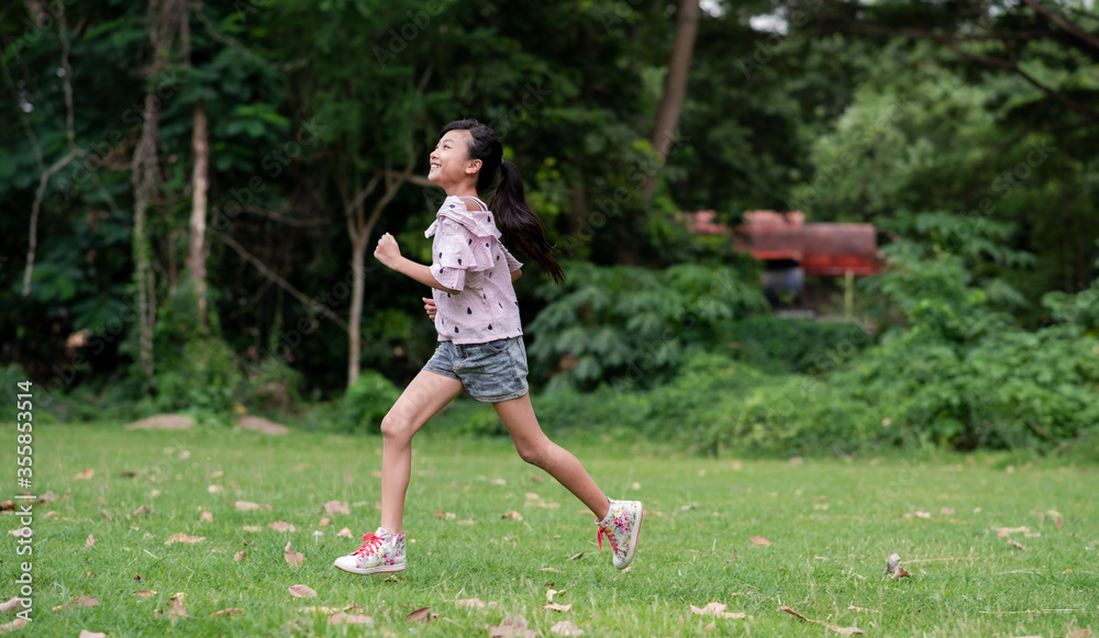 A girl Asian running on open grasslands A girl Asian running on open grasslands