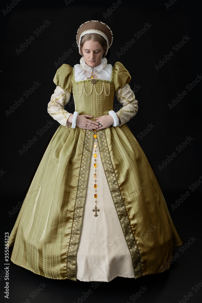 A Tudor woman in a gold dress against a dark background