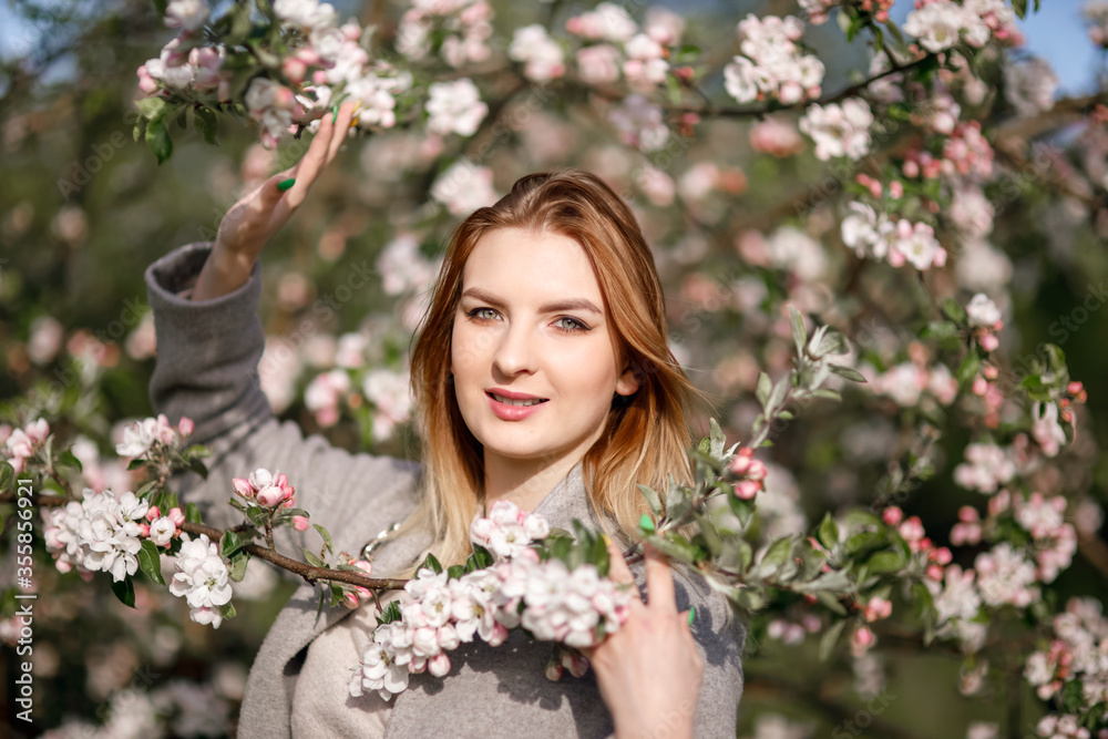 Young girl in a blooming apple orchard