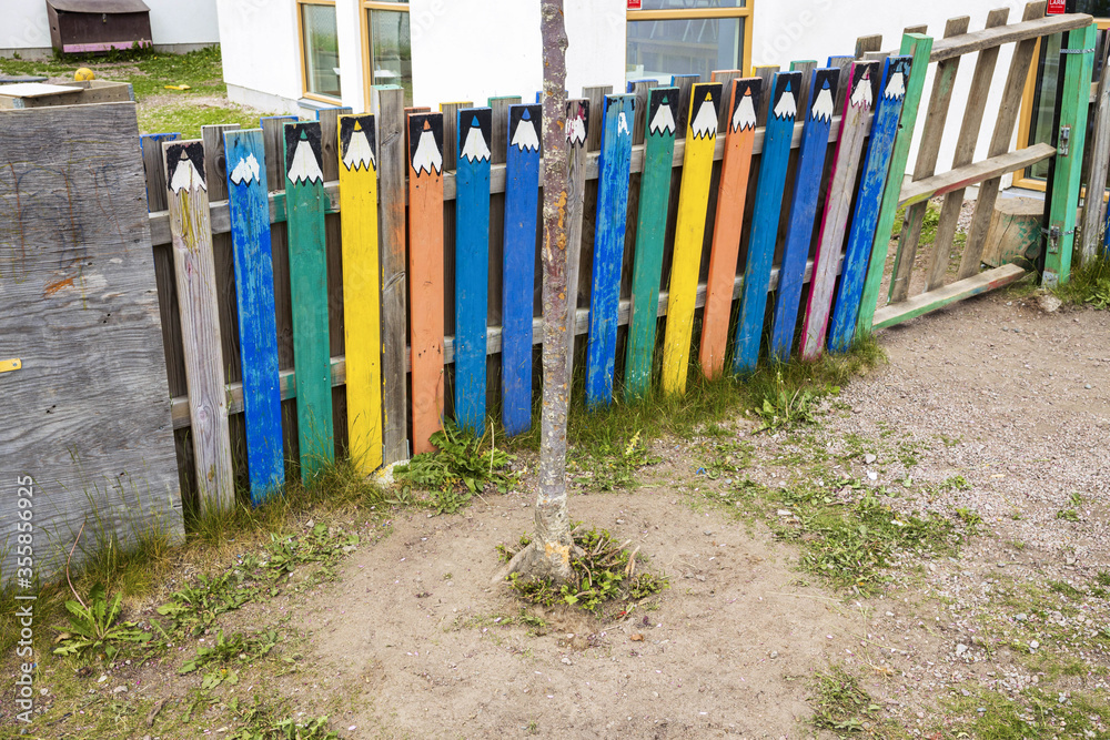 Beautiful view of colorful children garden fence in form of multicolored pencils. Exterior concept. 