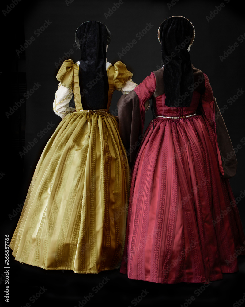 Two young women in Tudor costume talking and walking together