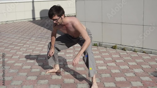 A man plays sports on the roof. A complex set of exercises based on gymnastics and karate.