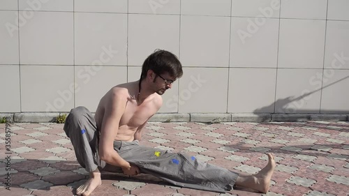 A man plays sports on the roof. A complex set of exercises based on gymnastics and karate.