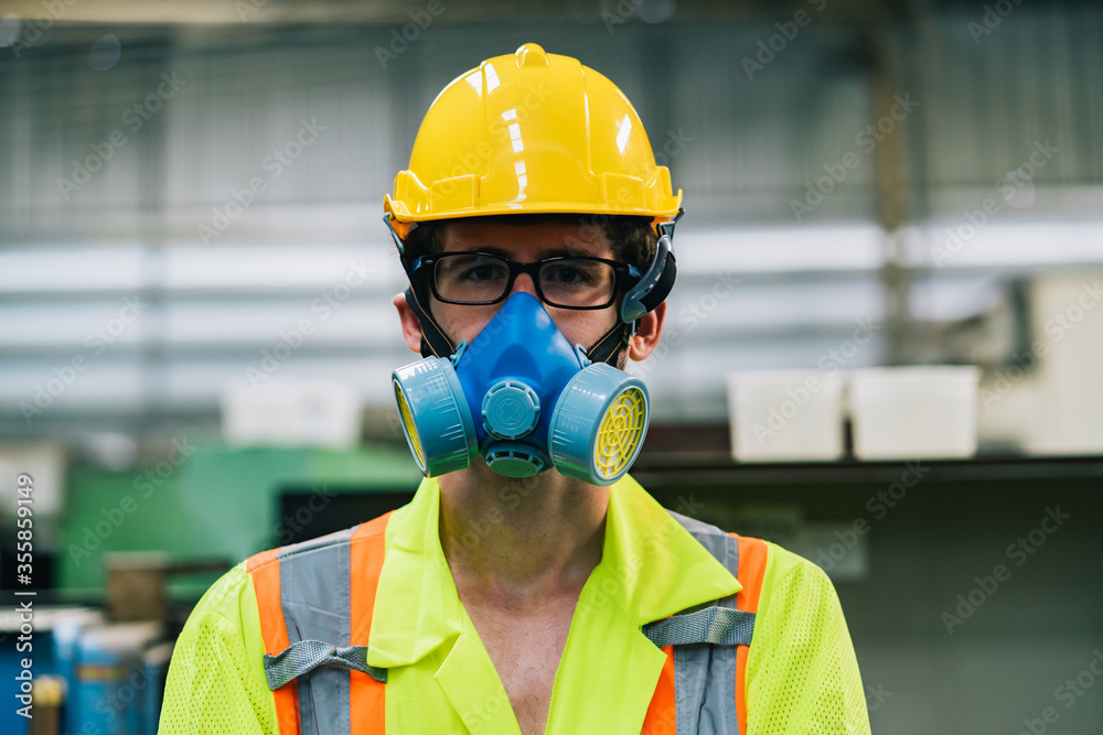Close up worker man caucasian wear a blue protective mask in safety jumpsuit uniform with yellow hardhat at factory Close up worker man caucasian wear a blue protective mask in safety jumpsuit uniform with yellow hardhat at factory