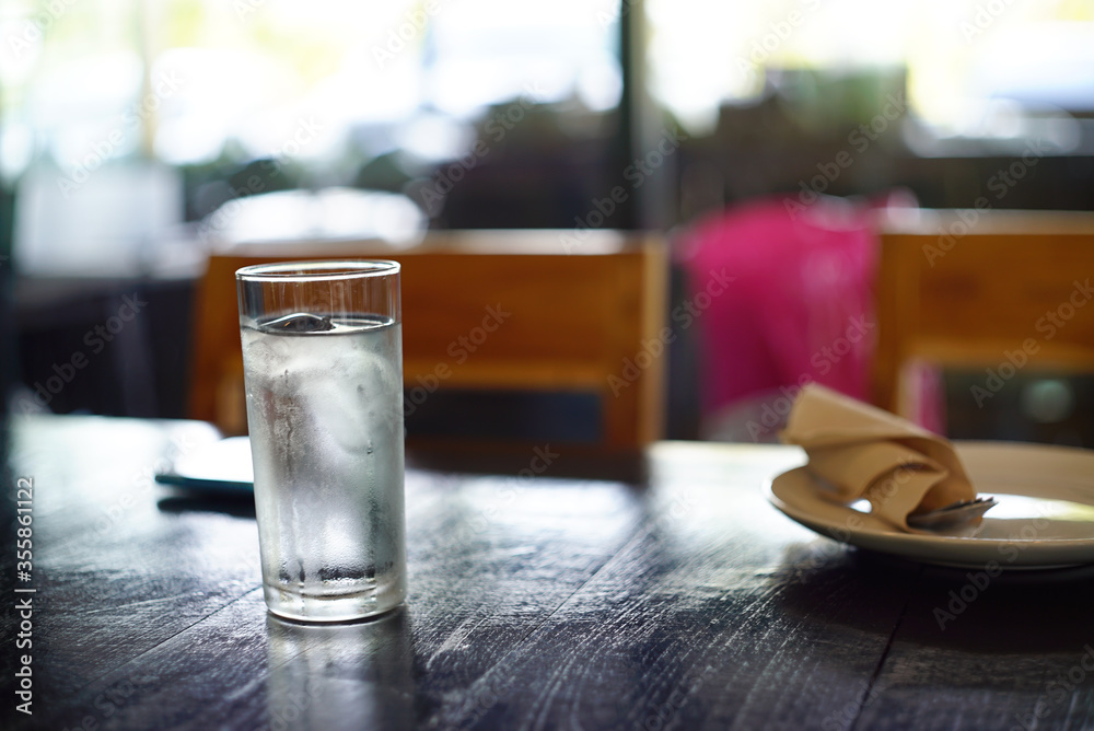 Ice water in glass and white dish on the table in restaurant
