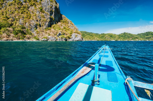 El Nido, Philippines. Island hopping Tour boat hover over open strait between exotic karst limestone islands on travel tour trip