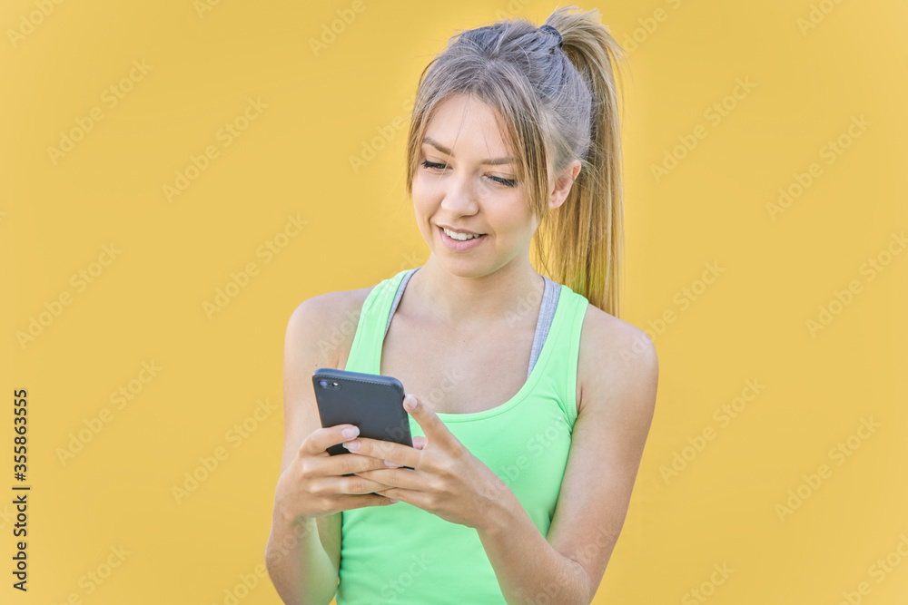 Pretty blonde girl sending a message through her cell phone