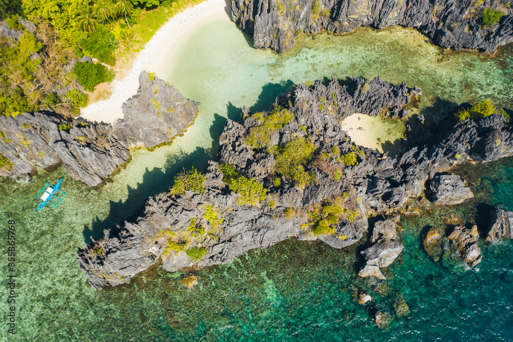 El Nido Palawan National Park. Hidden lagoon surrounded by lime stone rocks. White beach on tourist routes in the Philippines. Rocky formations on a tropical beach