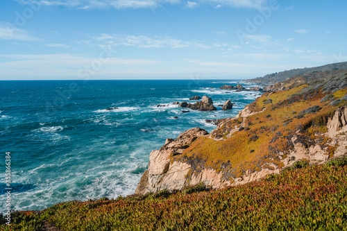 Beautiful landscape near Monterey city in California. Turquoise ocean with big waves and rocky cliffs