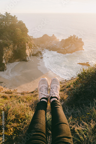 McWay Falls in Big Sur during the sunset autumn mood landscape. Julia Pfeiffer Burns State Park. Foots of a tourist against a waterfall photo