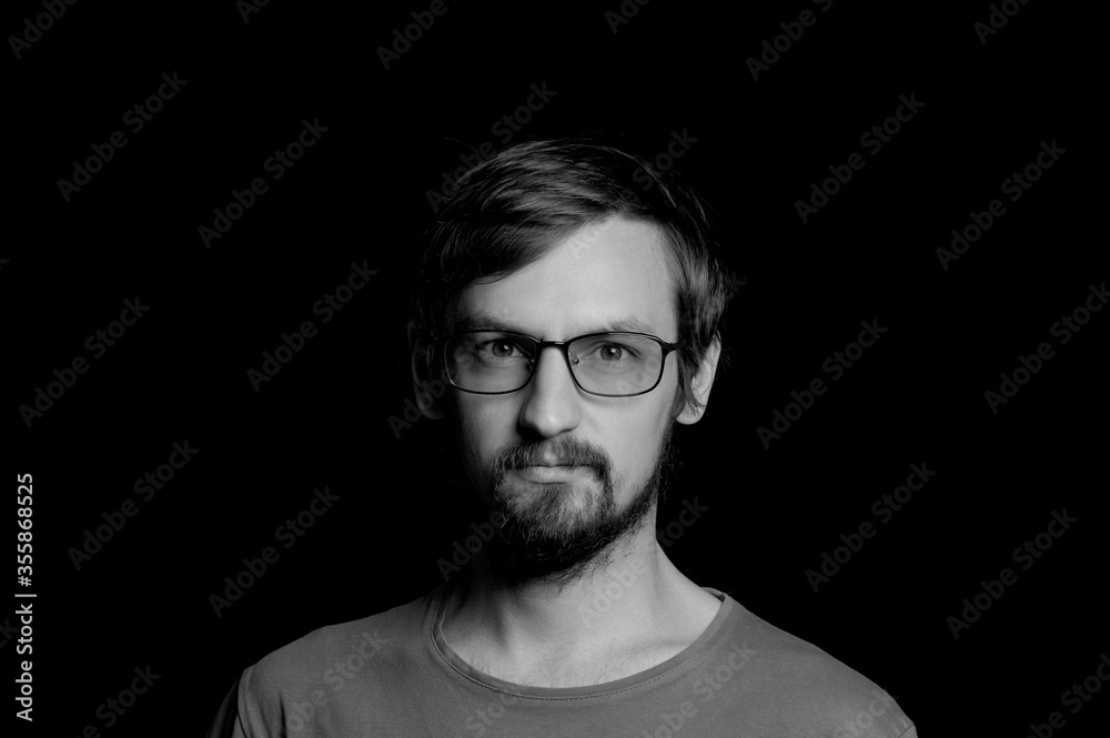 portrait of a guy with a beard in glasses on a black background portrait of a guy with a beard in glasses on a black background