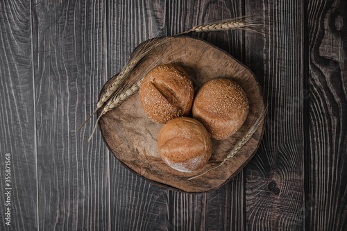 rustic crusty loaves of delicious fresh bakery bread and buns on cutting board.on a wooden table. top view. flat lay.